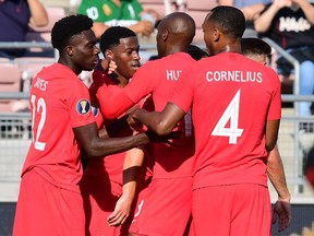 Canada's midfielder Alphonso Davies (left), midfielder Atiba Hutchinson (second from right) and forward Derek Cornelius (right) celebrate with forward Jonathan David (second from left) after he scored one of his two goals against Martinique on June 15, 2019, in Canada's 4-0 win to start the Gold Cup soccer tournament at the Rose Bowl in Pasadena, Calif.