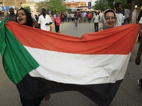 Sudanese women march with a national flag during a mass demonstration against the country's ruling generals in the capital Khartoum's central 'Khartoum 2' district on Sunday.