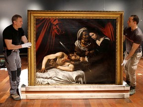 FILE PHOTO: Workers prepare to hang a painting entitled "Judith Beheading Holofernes", that might have been painted by Italian master Caravaggio (1571-1610), at the Drouot auction house in Paris, France, June 14, 2019.