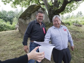 Chief Dalton Silver and land developer John Glazema hand off the papers after signing a letting to the government of British Columbia following a ceremony of Indigenous leaders in a call to save a First Nations burial site in Abbotsford, B.C., Friday, June 14, 2019.