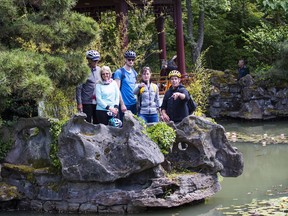 A group of tourists stops at the Sun Yat-sen garden during their cycle tour with guide Jeremy Catherall (with yellow helmet) in a tour called Dragons & Steam.