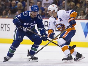 Vancouver Canucks Antoine Roussel's stick gets between the legs of New York Islanders' Cal Clutterback in the first period of a regular season NHL hockey game at Rogers Arena on February 23, 2019. Photo: Gerry Kahrmann/Postmedia