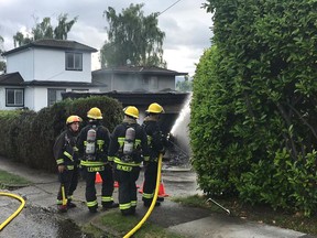 Vancouver firefighters douse a house fire in the city's west side on Monday morning.