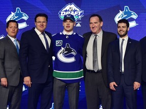 Vasili Podkolzin poses for a photo with Vancouver Canucks' brass after being selected 10th overall in Friday's first round of the NHL Entry Draft at Rogers Arena in Vancouver.