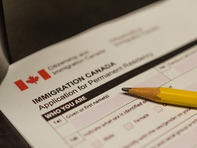 A pencil lies on a Canada immigration form.