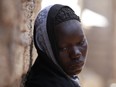 In this file photo taken Monday, May 19, 2014, Solome Ishaya, sister of kidnapped school girl Hauwa Ishaya, stands outside their family house in Chibok, Nigeria. Some 276 schoolgirls were abducted April 15 from a school in northeast Chibok town.