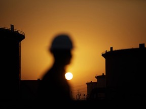 The sun sets over crude oil storage tanks at the Juaymah tank farm, operated by Saudi Aramco, in Ras Tanura, Saudi Arabia.