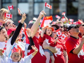 People take part in the living flag on the lawn of the legislature on Canada Day.