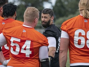 B.C. Lions quarterback Mike Reilly, centre, speaks with teammates during training camp at Hillside Stadium in Kamloops on May 20.