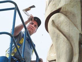 Carver James Harry works on the reconciliation pole outside the Vancouver School Board.