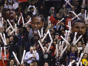 Toronto Raptors fans with Serge Ibaka, Kawhi Leonard and Drake cutout faces during a free-throw attempt by Golden State Warriors during the much-watched Game 1 of the NBA Finals.
