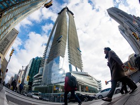 Pedestrians at the intersection of Yonge and Bloor Streets in Toronto, Ontario. Canada's households are clearly more stretched in terms of debt and spending than their American counterparts.