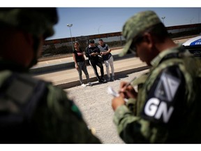 FILE PHOTO: Members of Mexico's National Guard detain Cuban migrants after they were trying to cross illegally the border between the U.S. and Mexico, in Ciudad Juarez, Mexico June 21, 2019.