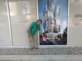 Author Bruno Huber holds his book, Folly Bistro, at the Denman Street site where the French bistro he once co-owned and co-managed and has now written about once stood.