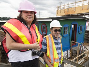 Esther Rausenberg and Glenn Alteen stand before the floating artist residency, which was being towed from Vancouver Pile Driving Inc. in North Vancouver to the Plaza of Nations in Vancouver on July 11.