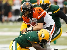 Edmonton Eskimos' Larry Dean (11) tackles BC Lions' quarterback Mike Reilly (13) during a CFL football game at Commonwealth Stadium in Edmonton, on Friday, June 21, 2019.