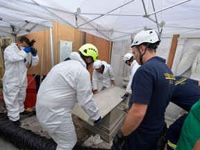 Vatican Media photo shows forensics officials and firefighters opening of one of two tombs within the Vatican's grounds in the Teutonic Cemetery on July 11, 2019, as part of a probe into the case of Emanuela Orlandi, a teenager who disappeared in 1983 in one of Italy's darkest mysteries.
