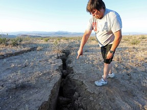 A man looks into a fissure that opened in the desert during a powerful earthquake that struck near the city of Ridgecrest, Calif., northeast of Los Angeles, on Thursday. California’s major quaker, coupled with some minor B.C. shocks, has had some people getting ‘a little nervous.’