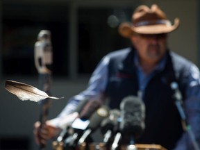 An eagle feather attached to a hat worn by Kwikwetlem First Nation Chief Ed Hall blows in the wind as Chief Joe Alphonse, back, Tribal Chair of the Tsilhqot'in National Government, speaks during a ceremony to commemorate the wrongful trial and hanging of Chief Ahan, in New Westminster on Thursday.
