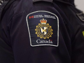 A Canadian Border Services agent stands watch at Pearson International Airport in Toronto on Tuesday, December 8, 2015. The Canada Border Services Agency will soon force all border security officers working with detained migrants to wear defensive gear, including batons, pepper spray and bulletproof vests, a policy that's drawing widespread concern over a perceived "criminalization" of asylum seekers.