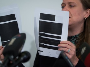 Meghan McDermott, a lawyer with the B.C Civil Liberties Association, holds a few redacted pages from the thousands disclosed by the Canadian Security Intelligence Service, during a news conference in Vancouver, on Monday July 8, 2019. The BCCLA alleges that CSIS was monitoring the organizing activities and peaceful protests of Indigenous groups and environmentalists who were opposed to the now-defunct Enbridge Northern Gateway Pipeline project.