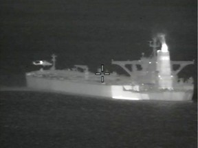 A helicopter hovers near the Iranian oil tanker Grace 1 off Gibraltar, according to Britain's Ministry of Defence, in a night vision photograph released July 4, 2019. British Royal Marines seized the Grace 1 tanker on Thursday for trying to take oil to Syria in violation of European Union sanctions.  MoD/Handout via REUTERS. NO RESALES. NO ARCHIVES.