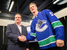 Newly acquired player Tyler Myers (right) and Jim Benning at Rogers Arena on July 1, 2019.