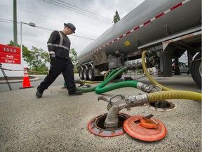 Fuel delivery driver David Pirzek fills underground tanks at a Petro-Canada in North Delta on July 4.
