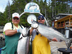 Steven Price, 72 (left), and son Doug Price are pictured in this 2013 Facebook photo hoisting their catches on a dock at Ole's Hakai Pass Fishing Lodge. Steven Price died last week after a float pair carrying the father-and-son pair went down on B.C.'s Addenbroke Island Friday. The pair were headed to the fishing lodge for an annual trip.