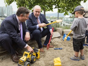 B.C. Premier John Horgan, centre, wants to play with the Daylight Saving Time issue now after an online government survey dealing with the time-change issue attracted a record response from British Columbians.