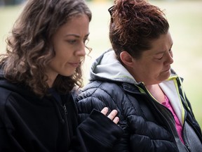 Wanda Stopa, right, who is currently living in a tent in a homeless camp, is comforted by Isabel Krupp, an activist with Alliance Against Displacement, during a gathering to remember friends, family and former residents who died in an area known as the "Whalley Strip", in Surrey, B.C., on Sunday July 7, 2019. Nearly 200 people had been camping on the stretch of 135A Street in Surrey when it was cleared by bylaw officers and RCMP last summer.