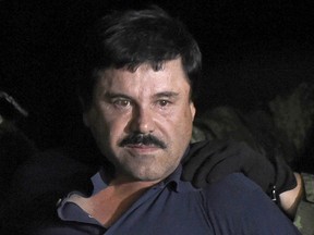 In this file photo taken on January 8, 2016, Drug kingpin Joaquin "El Chapo" Guzman is escorted into a helicopter at Mexico City's airport following his recapture during an intense military operation in Los Mochis, in Sinaloa State.