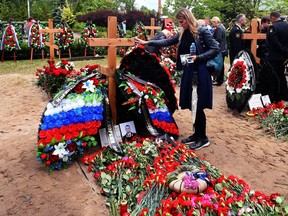 People mourn after a funeral ceremony at a cemetery in Saint Petersburg on July 6, 2019, three days after a fire that killed 14 officers on what was reportedly a nuclear-powered mini-submarine.
