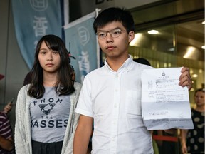 Hong Kong pro-democracy activists Agnes Chow (L) and Joshua Wong speak to the media after being arrested and released on bail on August 30, 2019 in Hong Kong.