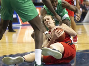 Canada’s Kelly Olynky (centre) gathers in a loose ball from Nigeria’s Al-Farouq Aminu and Ben Uzoh (right) during first-half FIBA basketball World Cup exhibition game action last night.  Chris Young/The Canadian Press