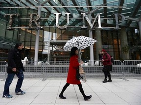 Pedestrians walk by the Trump International Tower and Hotel before a ceremony for the official opening on Feb. 28, 2017, in Vancouver.