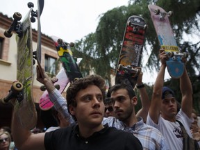 Skaters raise their skateboards during a vigil in tribute to Ignacio Echavarria, a victim of the London terror attack, outside of Las Rozas City Council on June 8, 2017 in Las Rozas, Madrid province, Spain.