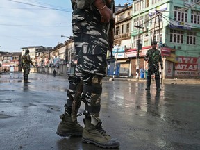 Indian security personnel stand guard on a street during a curfew in Srinagar on August 8, 2019, as widespread restrictions on movement and a telecommunications blackout remained in place after the Indian government stripped Jammu and Kashmir of its autonomy.