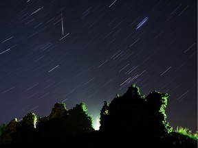 A long exposure picture shows a Perseid meteor crossing the night sky and stars trails above the ruins of a medieval castle in the village of Kreva, some 100 km northwest of Minsk, on August 12, 2019.