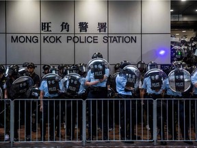 Police protect a police station against anti-government protesters in the Mong Kok district of Hong Kong on August 17, 2019, in the latest opposition to a planned extradition law that has since morphed into a wider call for democratic rights in the semi-autonomous city.