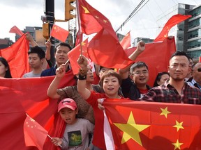 Pro-China supporters wave the Chinese flag during a demonstration at Broadway-City Hall SkyTrain Station in Vancouver on Aug. 17, 2019, backing the response of China's government to protests in Hong Kong.