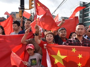 Pro-China supporters wave the Chinese flag during a demonstration at Broadway-City Hall SkyTrain Station in Vancouver.