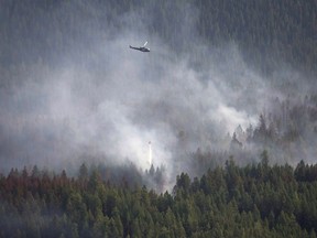 A helicopter dumps a load of water on the Philpot Road fire outside of Kelowna, B.C., Monday, August 28, 2017. New research suggests that bigger, hotter wildfires are turning Canada's vast boreal forest into a net source of climate-changing greenhouse gases.