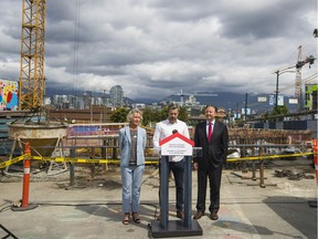 Treasury Board President Joyce Murray and Vancouver Mayor Kennedy Stewart flank Robert Purdy, president of the Catalyst Community Development Society, at Friday's announcement.