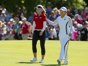 Jin Young Ko of South Korea walks up the 18th fairway with Brooke Henderson of Canada on her way to winning the CP Women's Open in Aurora, Ont., on Sunday, Aug. 25, 2019.