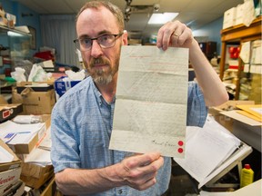 Brian Grant Duff with a document of an early land sale in Kitsilano, one of three being put up for auction.