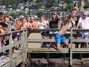 A man jumps off of the reopened White Rock pier on Aug. 27, 2019.