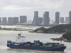 A container ship sails near downtown Xiamen, China, on Monday, Aug. 26, 2019.