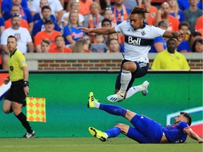 Vancouver Whitecaps forward Theo Bair (50) leaps over FC Cincinnati defender Mathieu Deplagne.