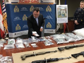 Surrey RCMP Sgt. Glenn Leeson holds some of the drugs seized, while Const. Richard Wright looks on.